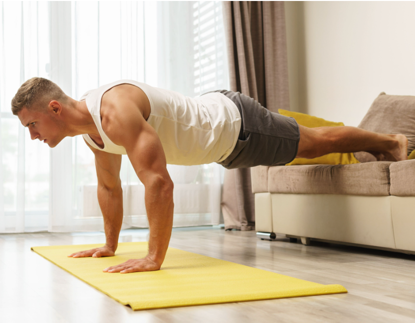 a fitness man doing push ups on the couch at home 