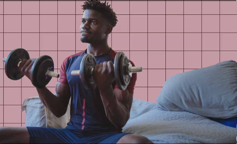  young man doing biceps curls at home with dumbbells 